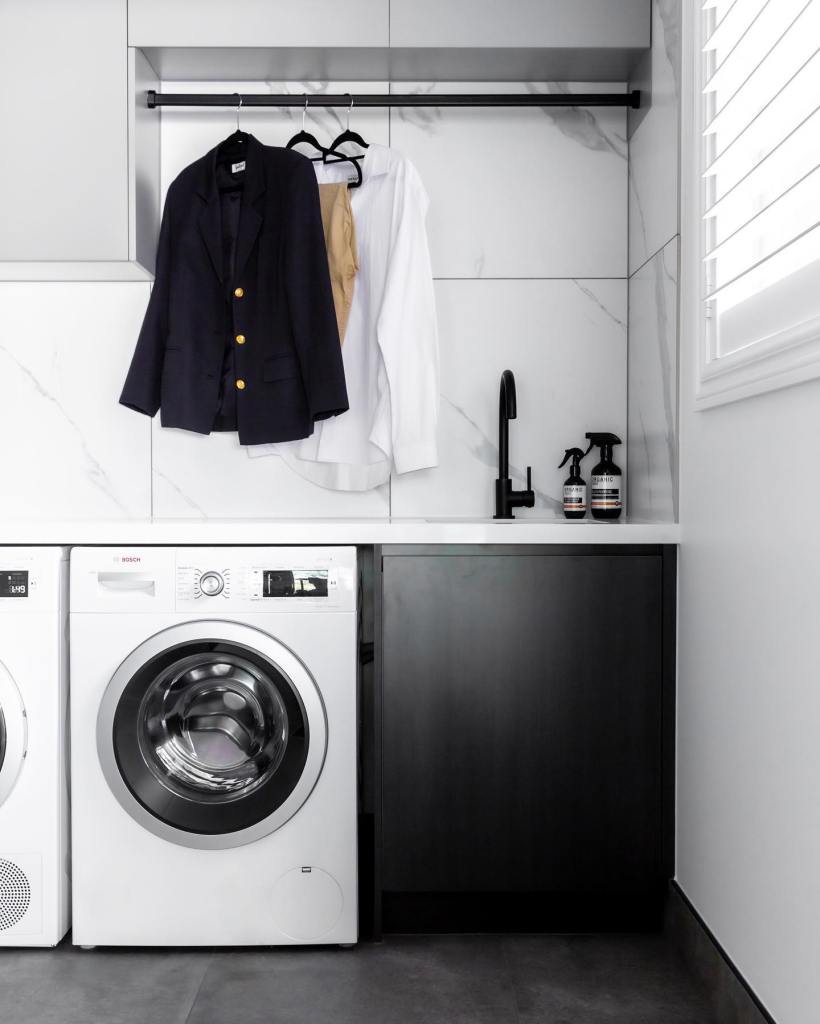 A modern laundry room featuring two front-loading washing machines. This image depicts a contemporary laundry room with sl...